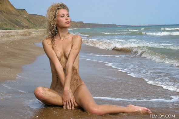 Голая блондинка наслаждается отдыхом на море