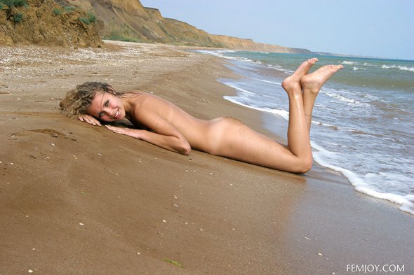 Голая блондинка наслаждается отдыхом на море