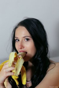 Молоденькая голая брюнетка ест банан