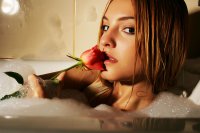 Девушка с розой позирует в ванне