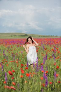 Молодая голая девушка на маковом поле