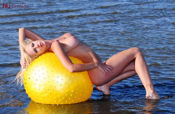 Голая девушка с большим мячом на море