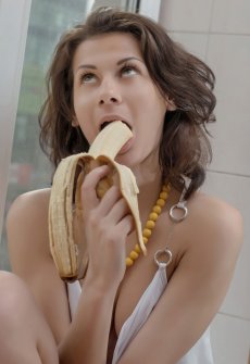 Девушка ест банан на подоконнике