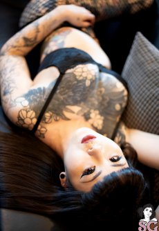 Изящная азиатка показывает татуировки на сиськах и на ногах
