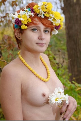 Деревенская девушка в венке из полевых цветов нагая чувствует единение с природой